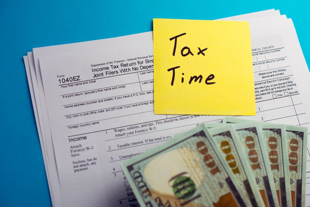 Individual income tax return 1040 ez tax form with money on table. Lodging your tax return